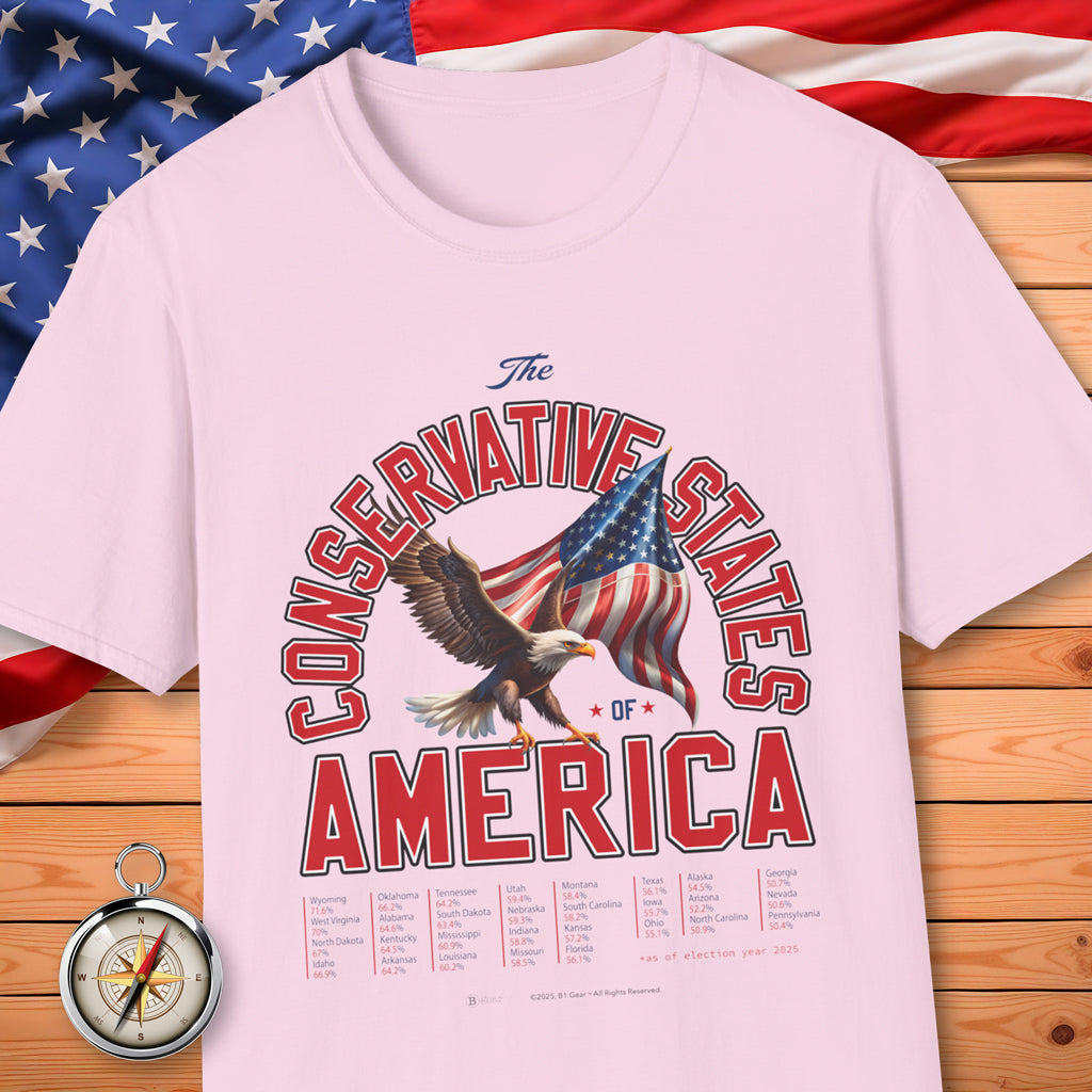 Pink t-shirt with 'The Conservative States of America' design featuring an eagle and American flag on a wooden surface with an American flag in the background.