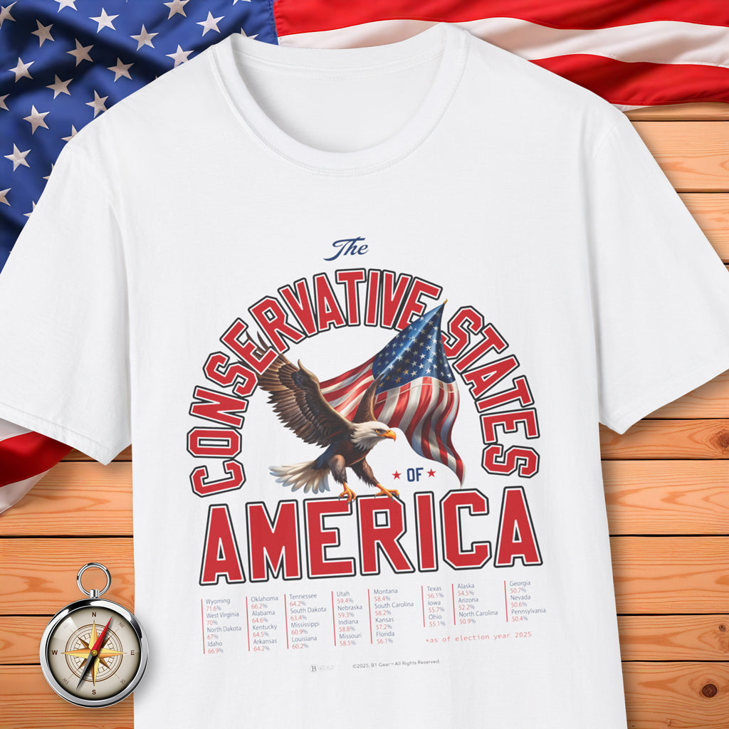 White t-shirt with 'The Conservative States of America' design featuring an eagle and American flag on a wooden surface with an American flag in the background.